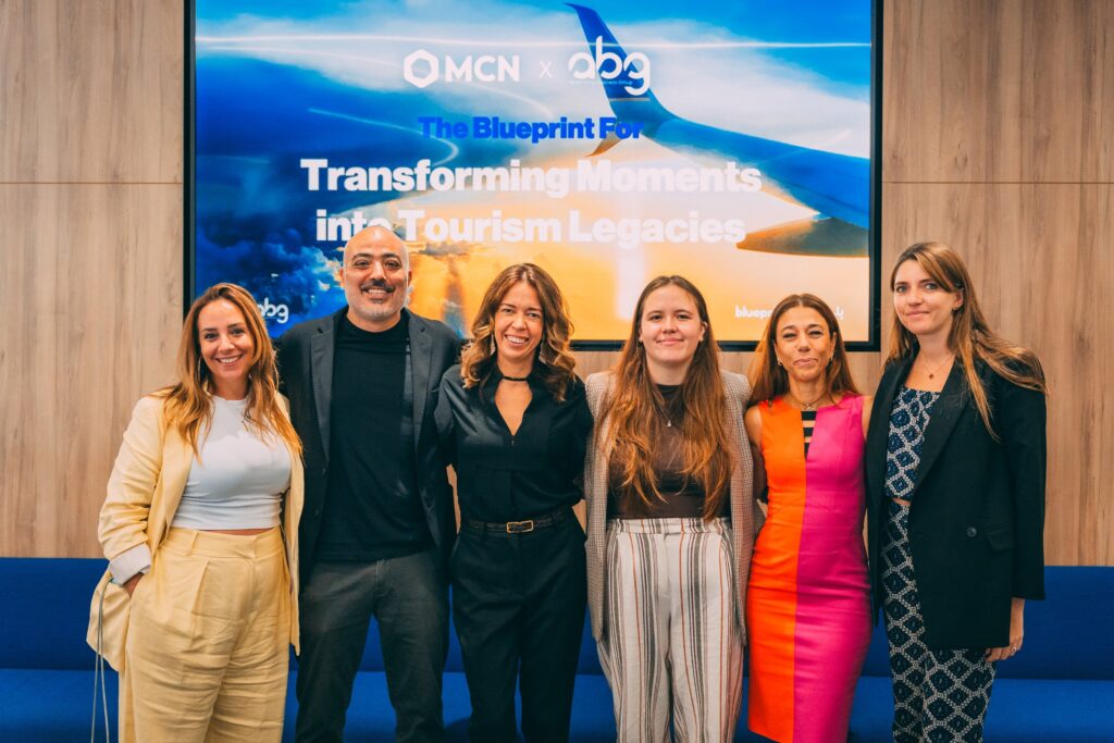 ABG leadership team standing together at a marketing industry event in front of a presentation screen.